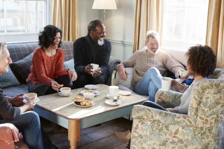 Group of older friends talking around a coffee table