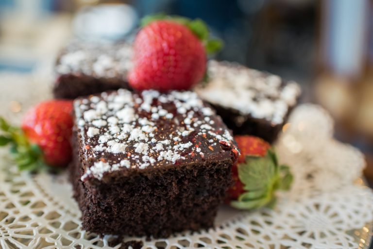 Brownie topped with powdered sugar and strawberries