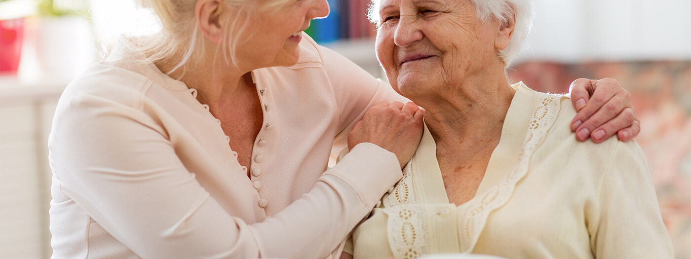 Memory care resident and resident care assistant enjoying a cup of tea