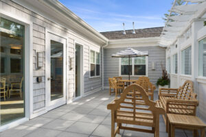 Enclosed second floor patio with chairs and a bench