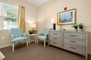 Chairs clustered next to a low dresser in a Duxbury House memory care studio apartment