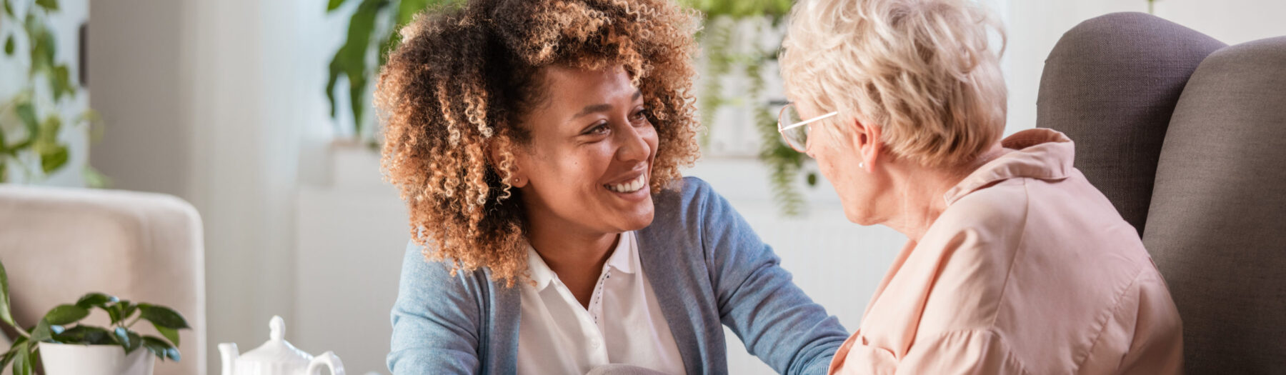Friendly caregiver supporting a senior lady at memory care community