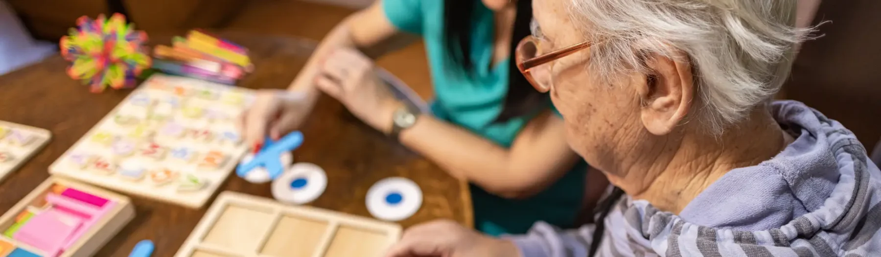 senior man and caregiver play tic-tac-toe and other memory games for dementia